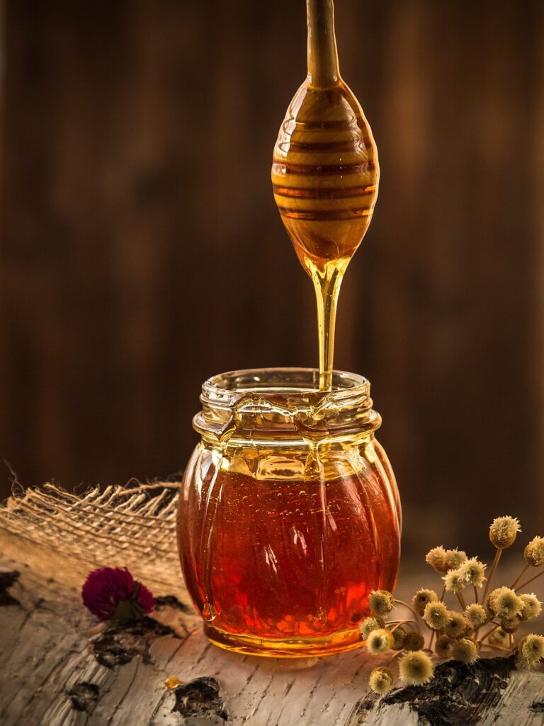 Mānuka honey dripping into a glass jar – natural skincare ingredient